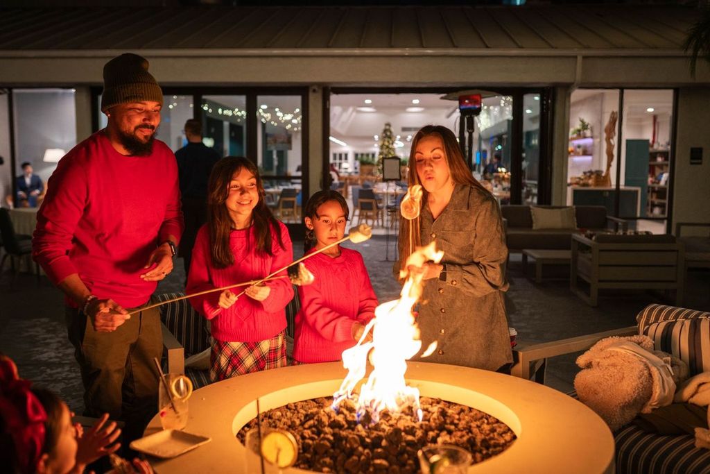 Families enjoy s'mores over a fire